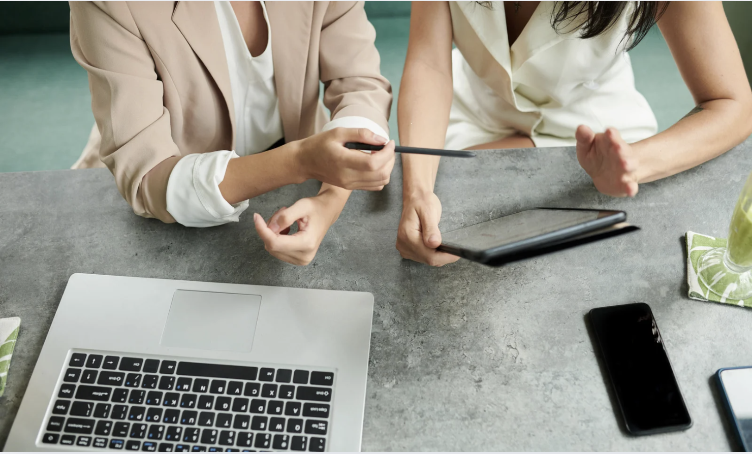 two people looking at a computer and tablet